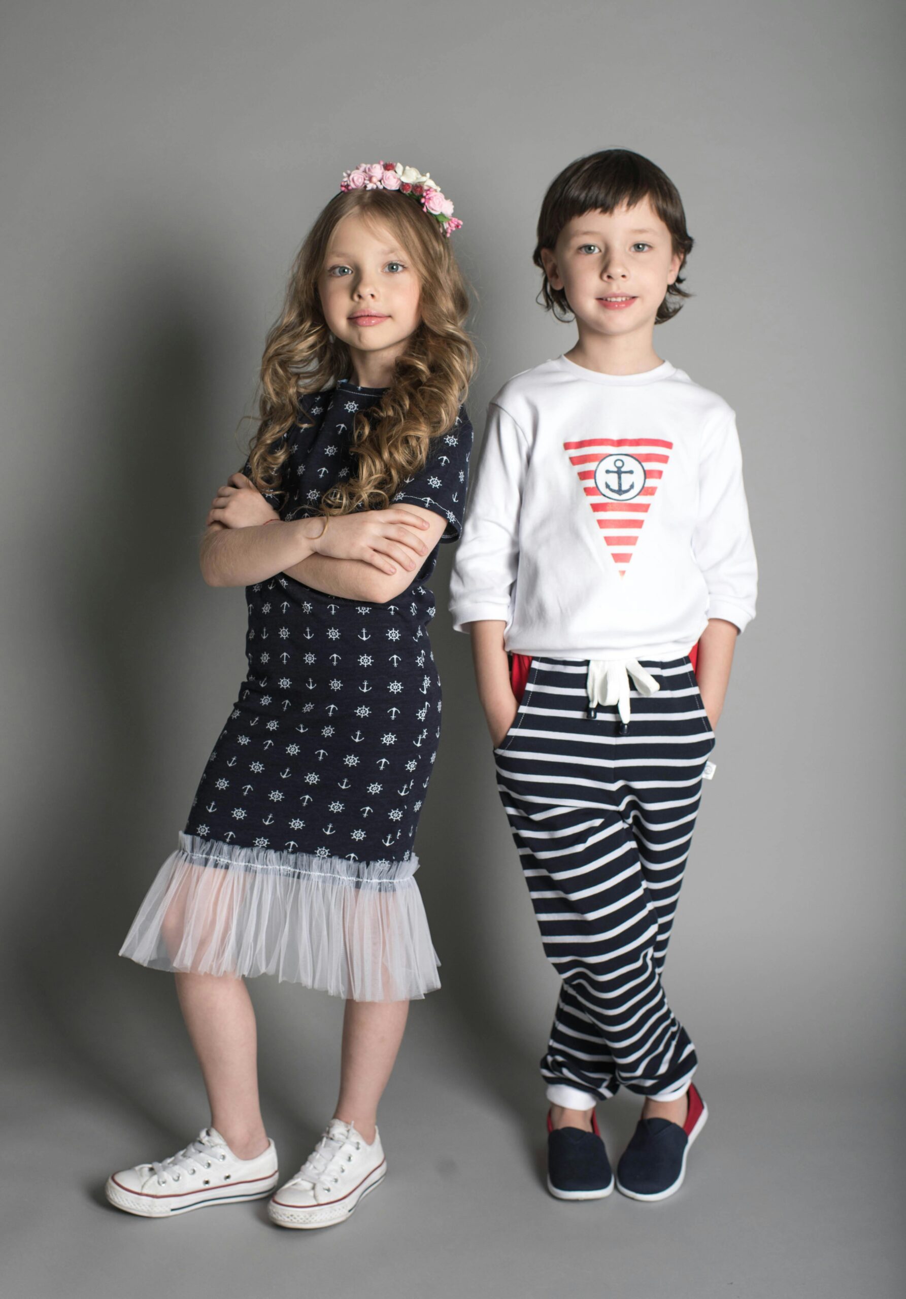 Two children posing in stylish nautical-themed outfits.